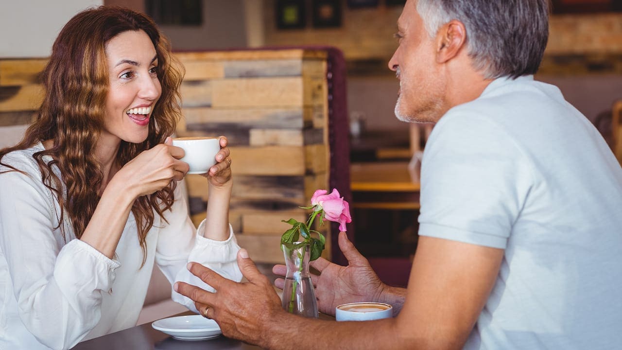 Middle-aged couple on a date enjoying coffee.